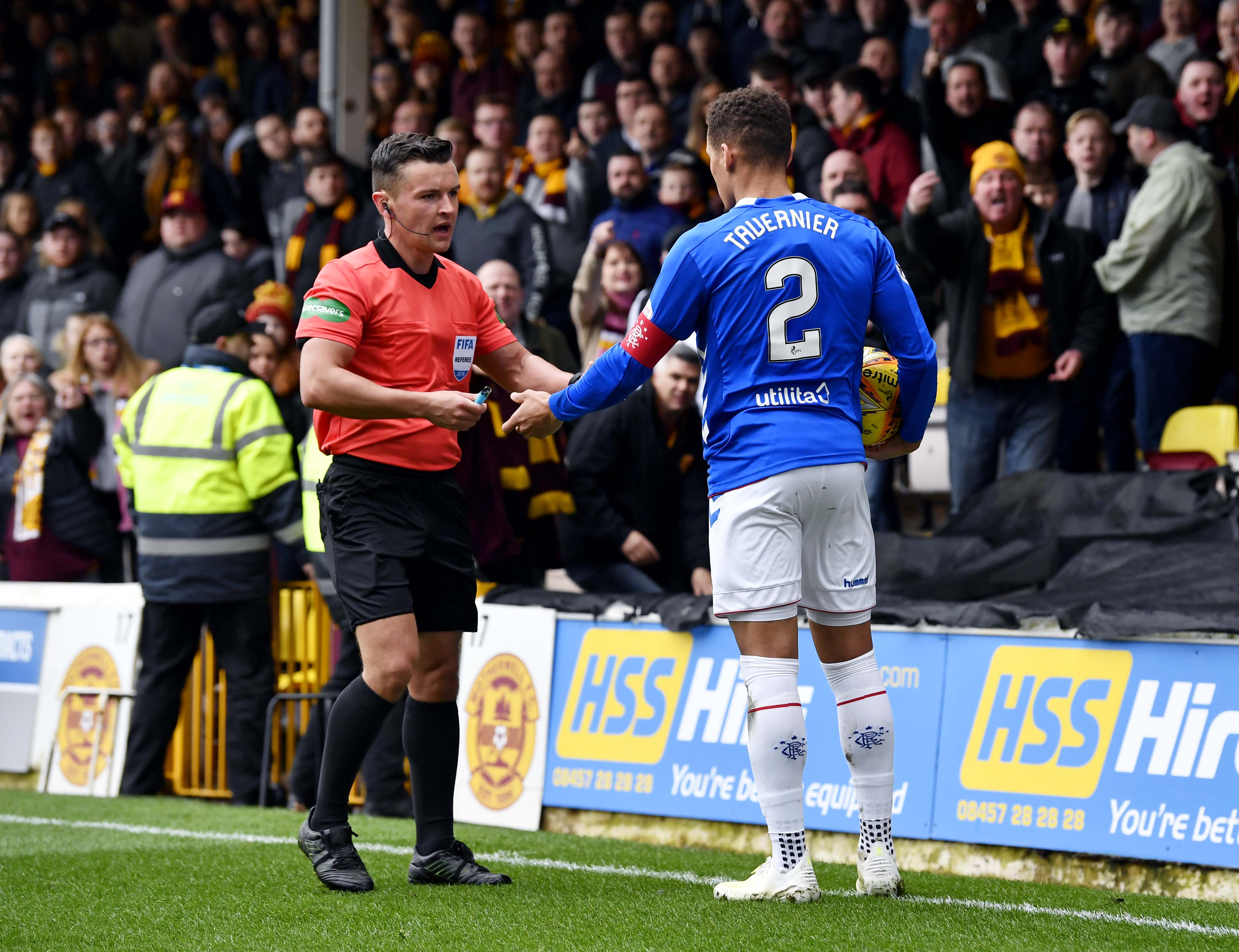 Rangers' James Tavernier spots an object thrown from the Motherwell fans as he goes to take a throw in and hands it to referee Nick Walsh