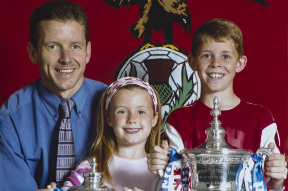 Ryan Christie was keen to get his hands on silverware from an early age, 
pictured here with his dad and sister, Paige, in 2004