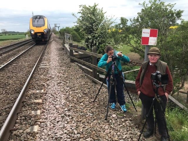 Two people standing next to a 125mph train line in Elford, Staffordshire to catch a close glimpse of Flying Scotsman