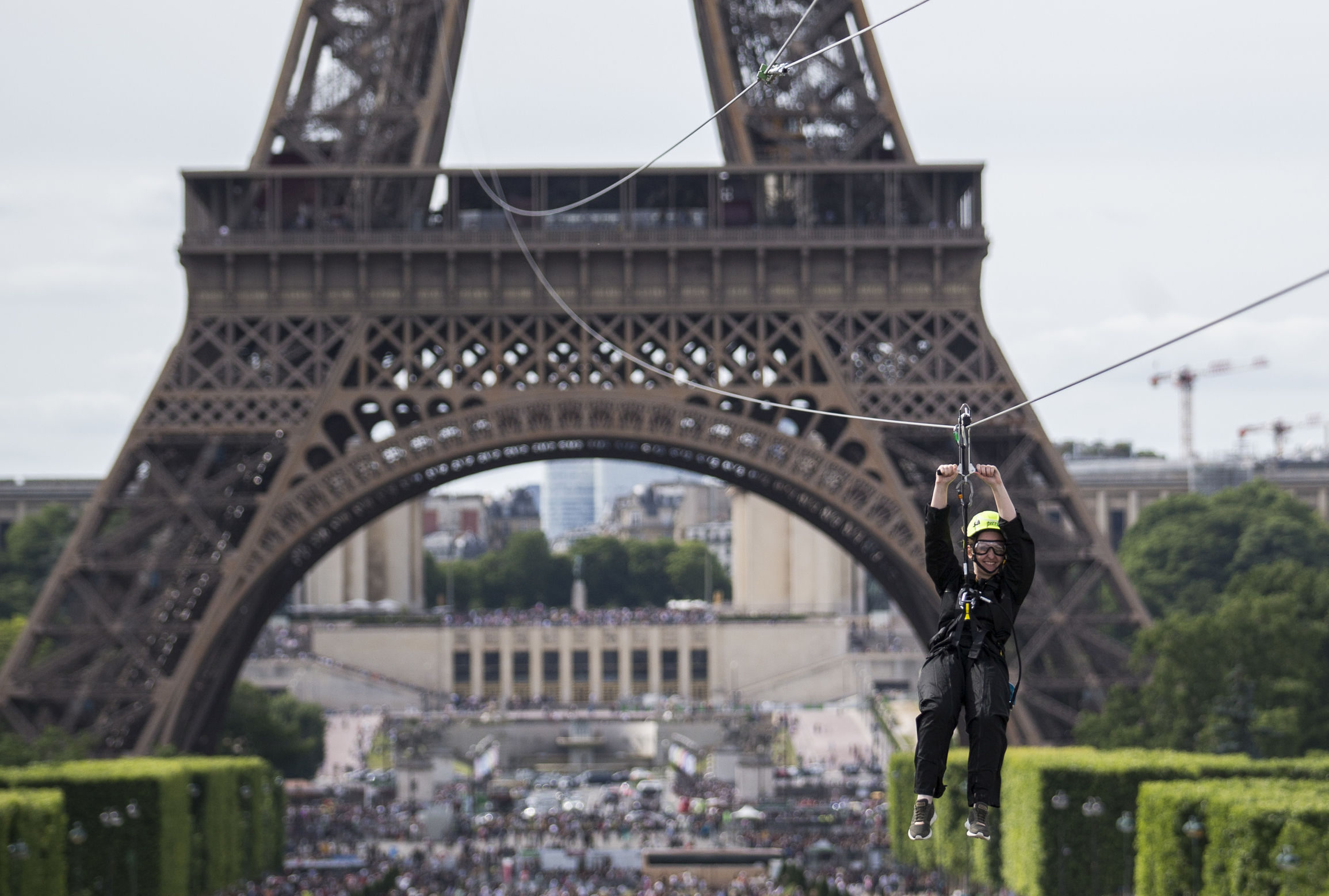 A woman zipslides from the Eiffel Tower