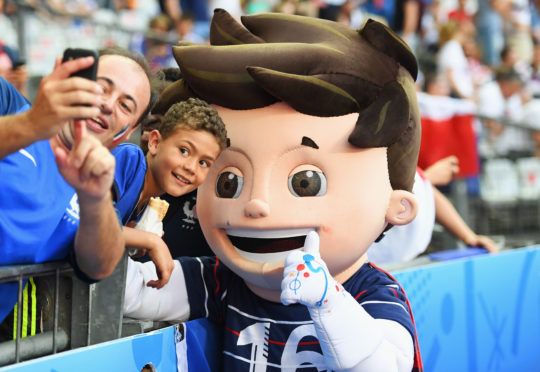 Fans take photographs with Euro 2016 mascot Super Victor prior to the championships final in Paris