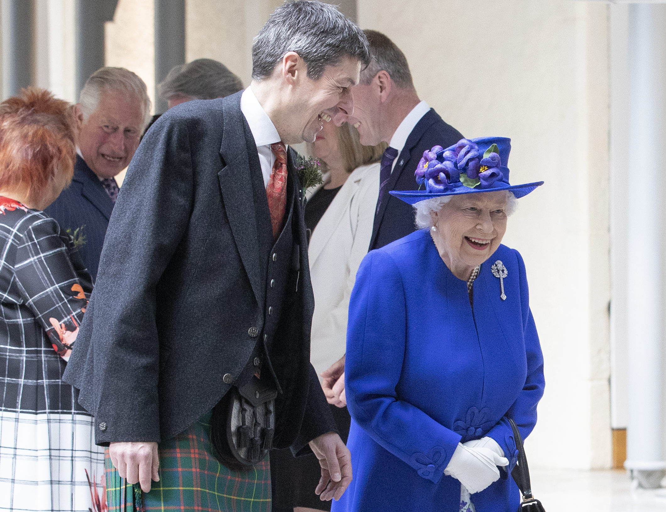 Queen Elizabeth II accompanied by Presiding Officer of the Scottish Parliament Ken Macintosh as they walk through the Garden Lobby at the Scottish Parliament in Edinburgh ahead of a ceremony marking the 20th anniversary of devolution in the Holyrood chamber. on June 29, 2019 in Edinburgh, Scotland.