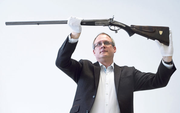 Dr Patrick Watt with rifle gifted to a servant by Queen Victoria