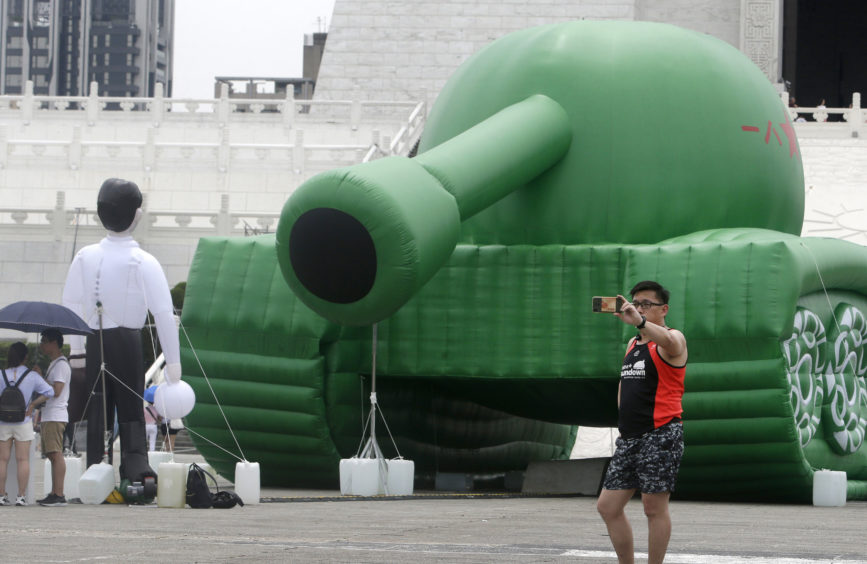 A Taiwanese man takes a selfie in front of an inflatable installation at the Liberty Square of Chiang Kai-shek Memorial Hall in Taipei, Taiwan yesterday. An artist erected the inflatable tank and man display in Taiwan’s capital to mark an iconic moment in the Tiananmen Square pro-democracy protests which occurred on June 4, 1989