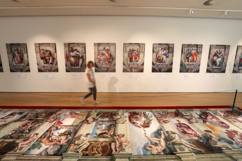A visitor admires the stunning reproduction of Sistine Chapel frescoes in the UK premiere of Michelangelo exhibition at Winchester Discovery Centre