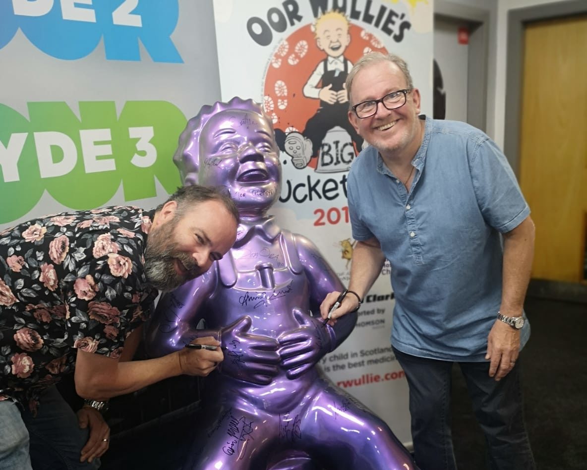 Greg Hemphill and Ford Kiernan sign an Oor Wullie statue as part of the Oor Wullie's BIG Bucket Trail, now at its halfway point.