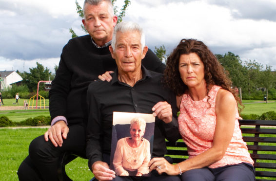 Mark Baxter, his sister Audrey and his dad Chic hold a picture of Eileen