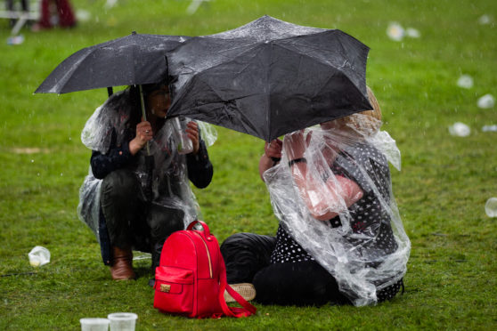 Music fans sheltering from the rain at Playground Festival, Rouken Glen Park, yesterday