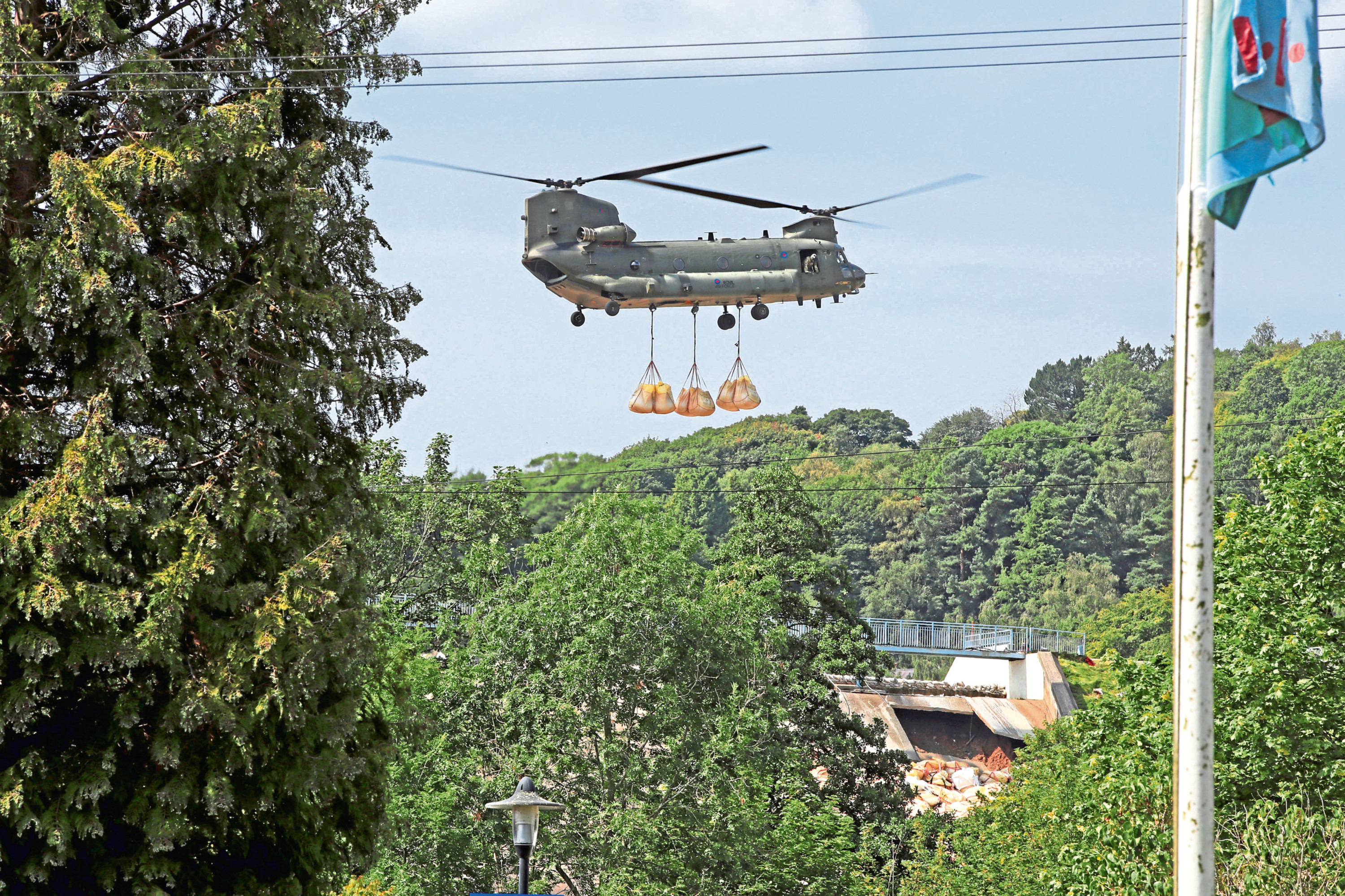 An RAF Chinook helicopter flies in sandbags to help repair the dam at Toddbrook reservoir near the village of Whaley Bridge in Derbyshire
