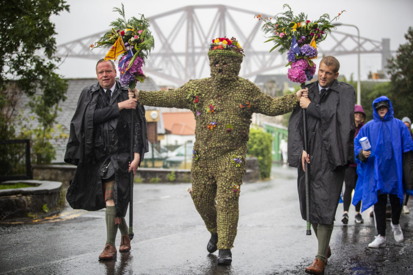 Burryman Andrew Taylor, accompanied by Andrew Findlater (left) and Duncan Thompson (right), meets residents as he parades through the town of South Queensferry