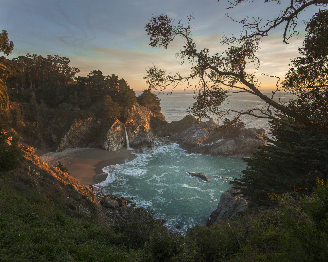 The sun sets over McWay Falls in Big Sur, Monterey, California.