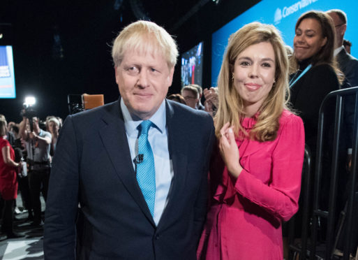 Prime Minister Boris Johnson exits the hall with his girlfriend Carrie Symonds following his keynote speech on day four of the 2019 Conservative Party Conference at Manchester Central on October 2, 2019 in Manchester, England.