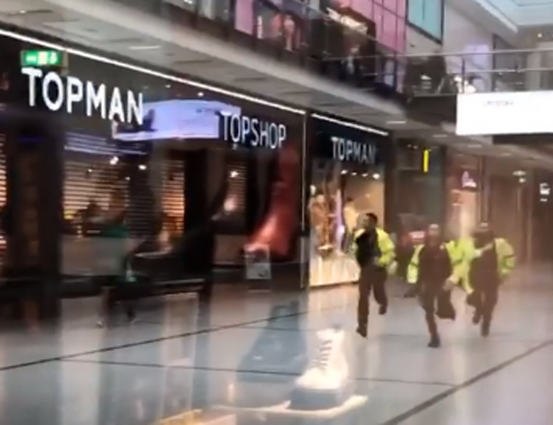 Police running through the Arndale Centre in Manchester in response to the incident