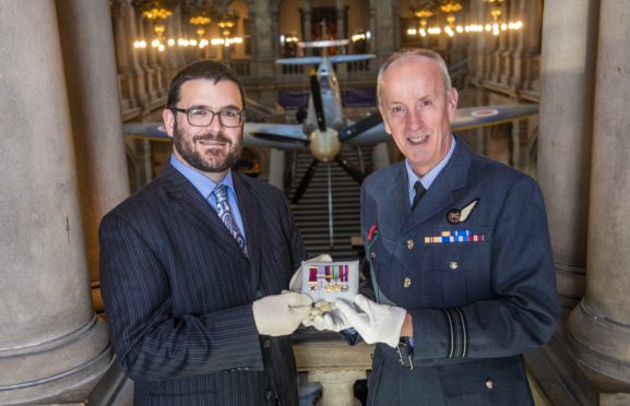 Glasgow Museums curator John Messner (L) and Squadron Leader  Archie McCallum of the 602 City of Glasgow Squadron unveil the new display