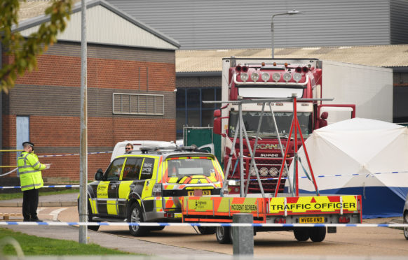 The lorry in which 39 migrants were found dead is secured behind a police cordon in Grays, Essex, after grim discovery on Wednesday