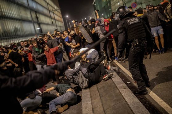 Police clash with protesters during a demonstration at El Prat airport, outskirts of Barcelona, Spain, Monday, Oct. 14, 2019. Spain's Supreme Court on Monday sentenced 12 prominent former Catalan politicians and activists to lengthly prison terms for their roles in a 2017 bid to gain Catalonia's independence, sparking protests across the wealthy Spanish region.