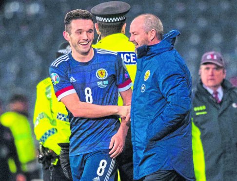 Scotland's John McGinn (L) shakes hands with manager Steve Clarke during the UEFA European Championship Qualifier between Scotland and Kazakhstan at Hampden Park, on November 19, in Glasgow, Scotland.