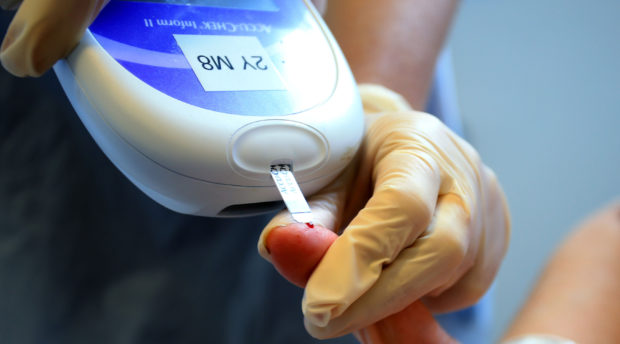 A nurse giving a patient a diabetes test