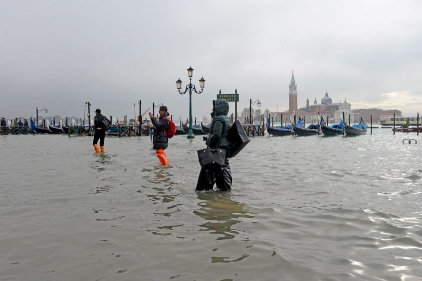 People walk in the high water