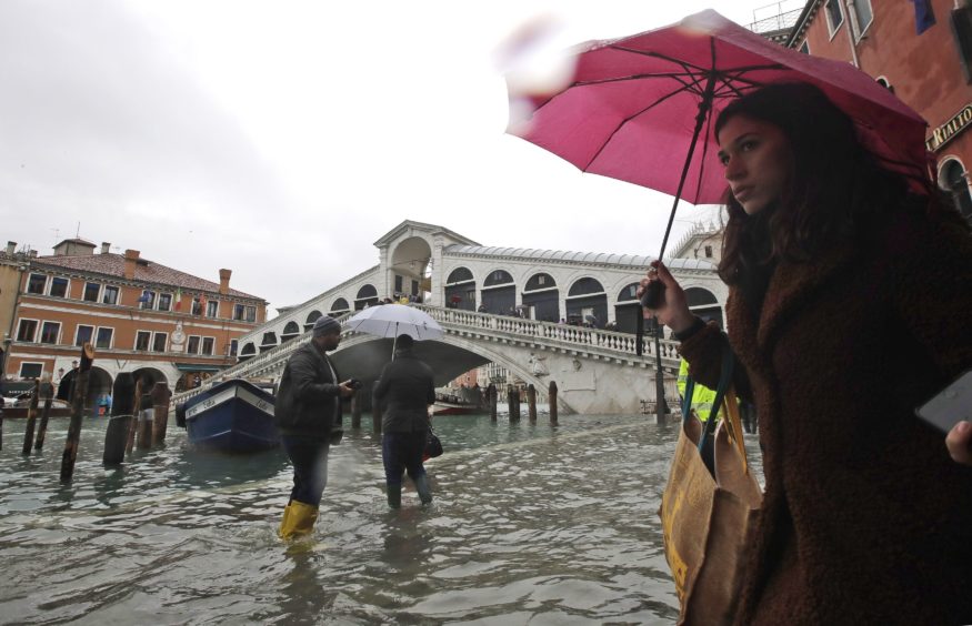 People walk near the Rialto bridge