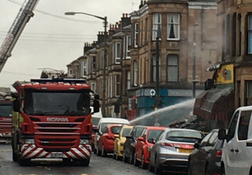Firefighters remain at scene of huge blaze and tenement collapse in