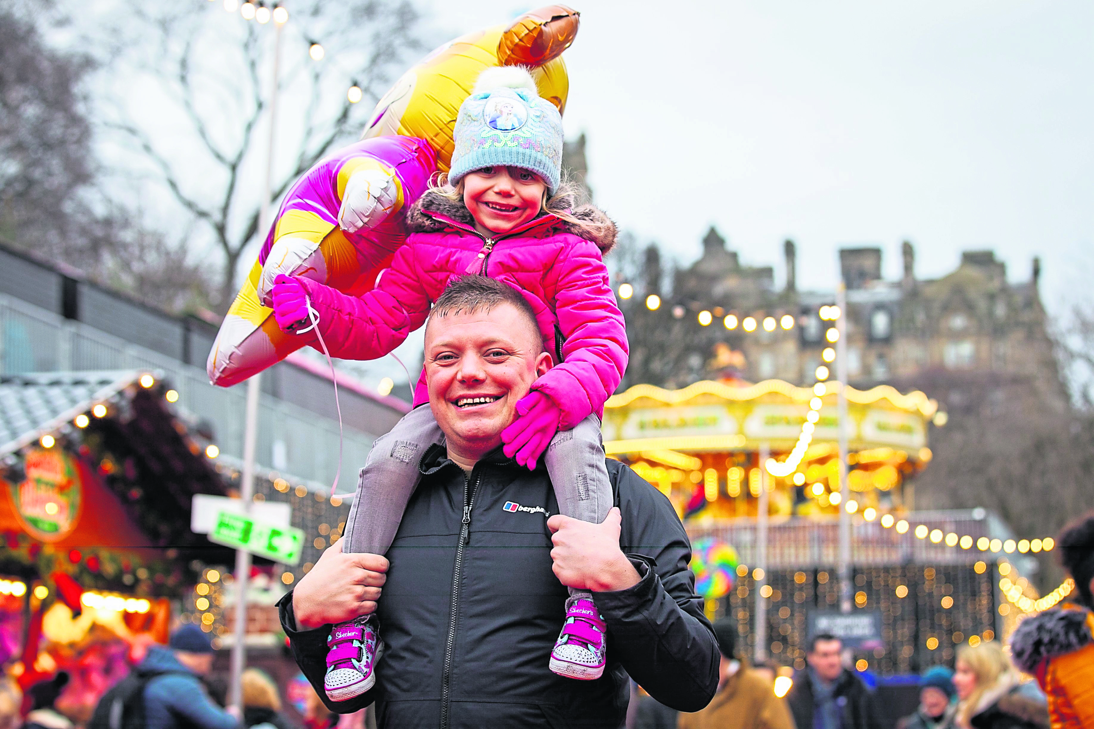 Families enjoying the Christmas fairground and market at Princes Street Gardens, in Edinburgh. Pic shows Joe Longbottom, with daughter Bobbie, age 4, from Leeds.