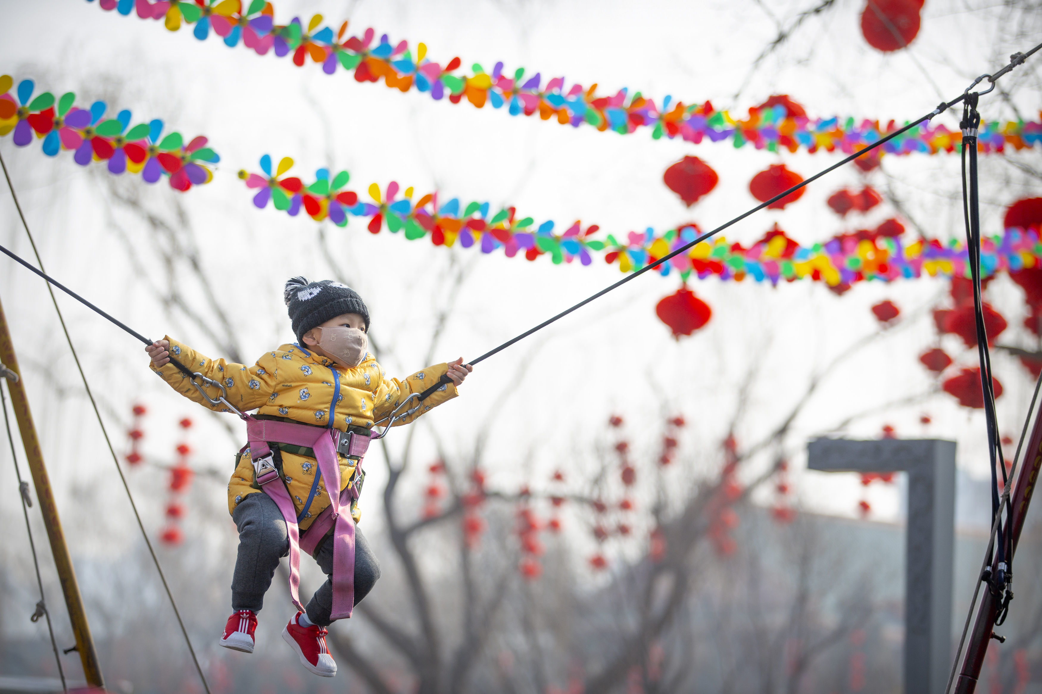 A child wearing a face mask on a ride at a fair in Longtan Park in Beijing yesterday
