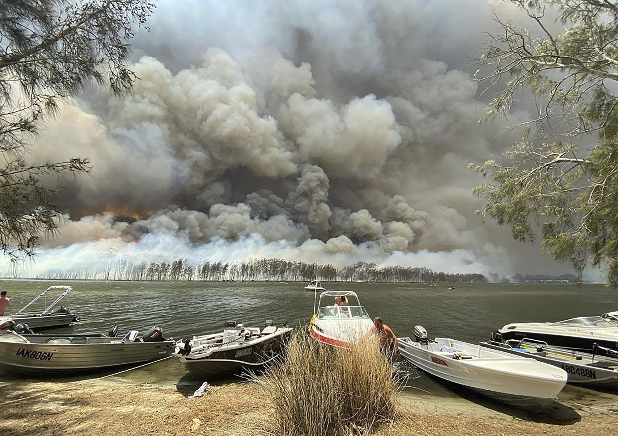 Smoke and wildfire rage behind Lake Conjola in Australia as residents and tourists fled the flames raging across the country’s eastern coast last week