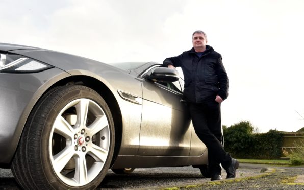 Bruce Collie beside his Jaguar XE