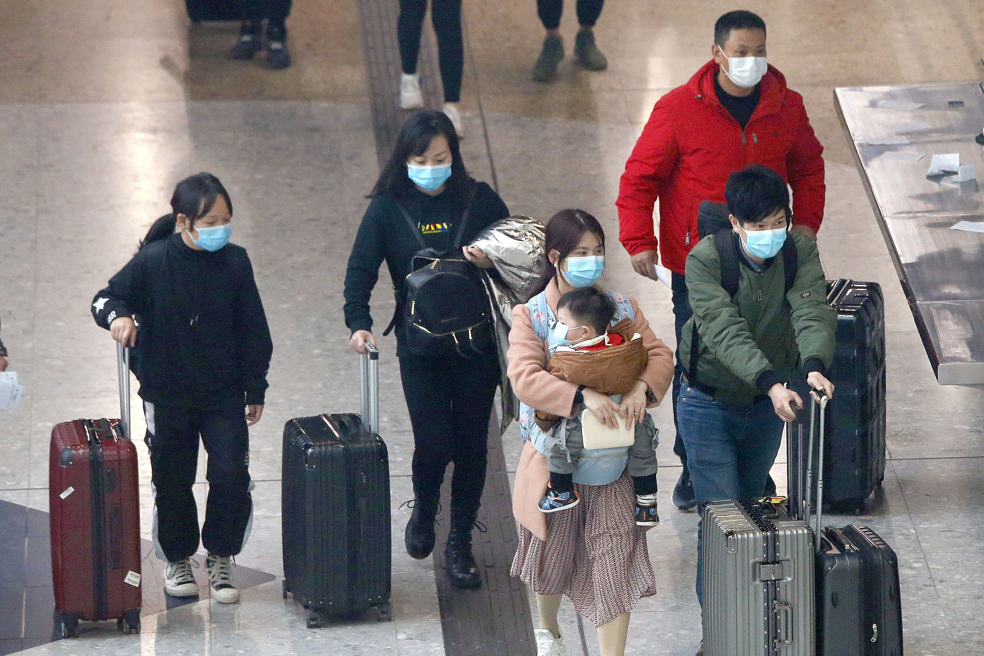 Travellers in Hong Kong wear masks