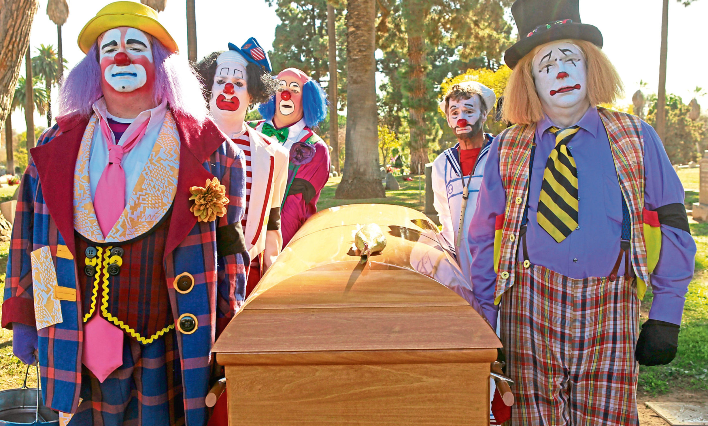 Cam (Eric Stonestreet, left) and fellow clowns take beloved mentor Al to his final resting place in TV series Modern Family