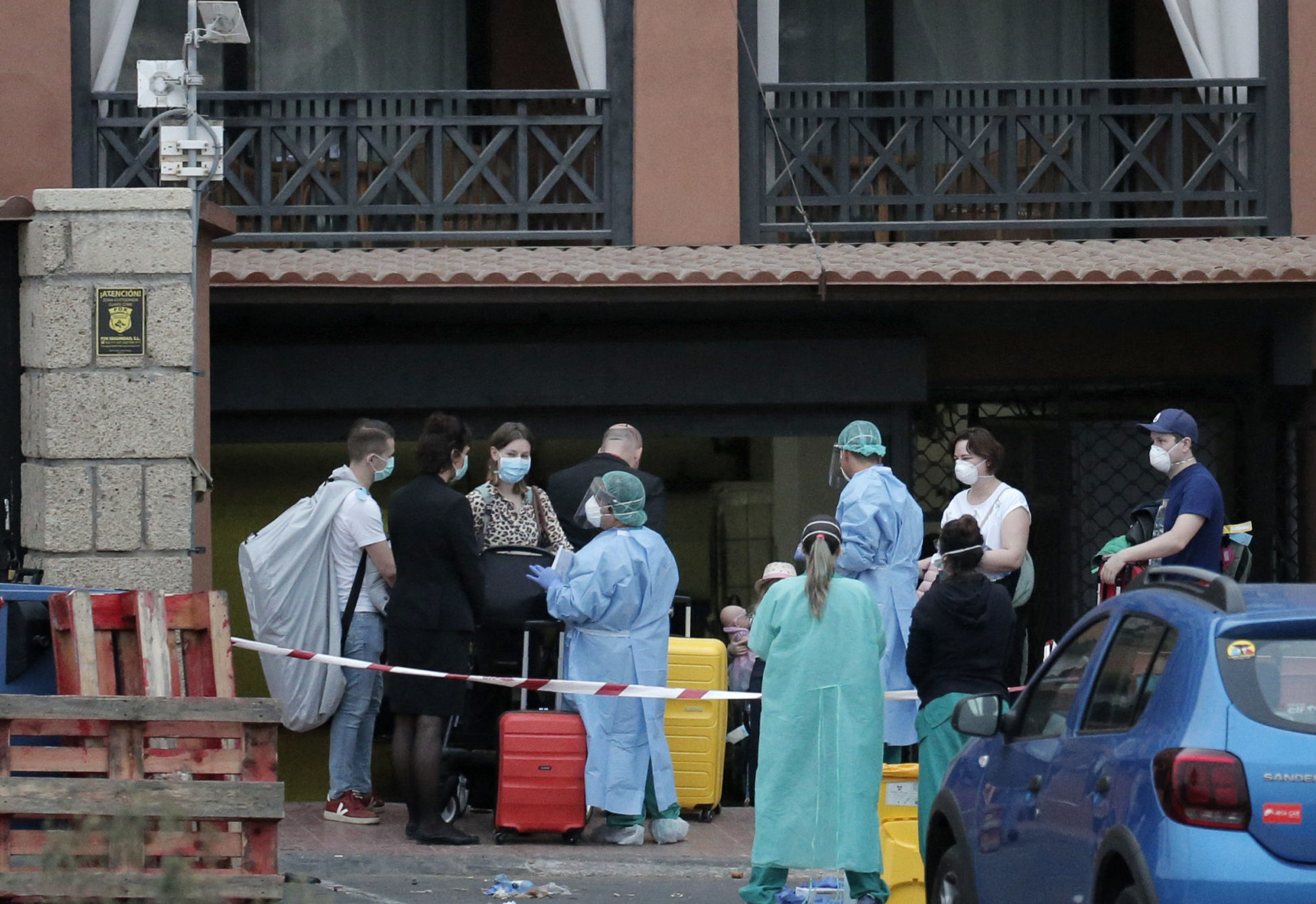 Health workers help guests leave the H10 Costa Adeje Palace hotel in Tenerife which has been under lockdown since an outbreak of coronavirus at the resort