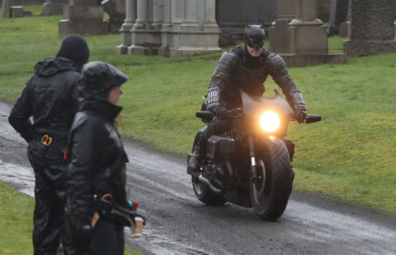 A man dressed as Batman during filming at the Glasgow Necropolis