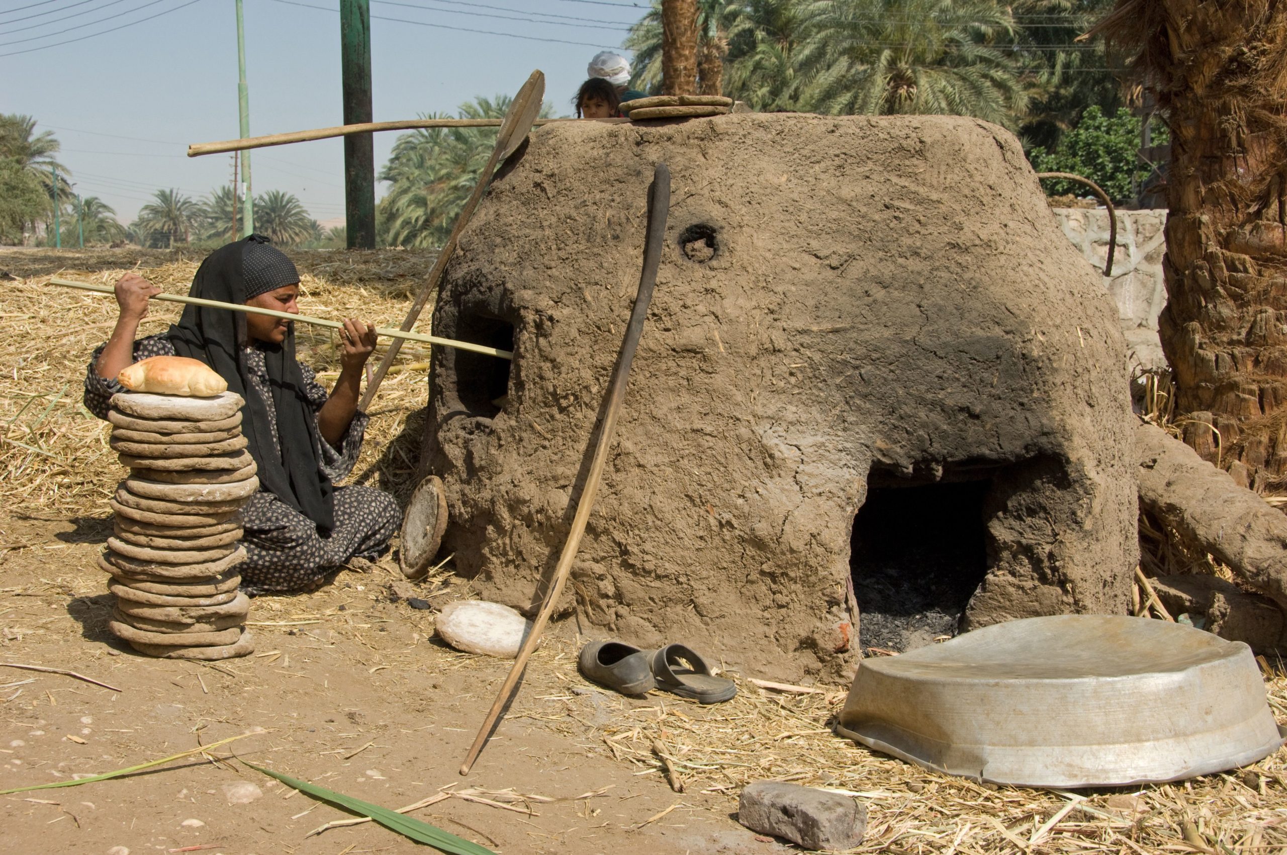 A labourer baking bread in a mud oven in Luxor, Egypt