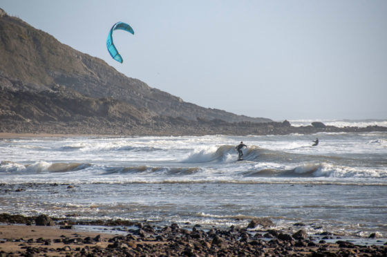Surfers enjoying the waves at Langland Bay near Swansea during Storm Ciara