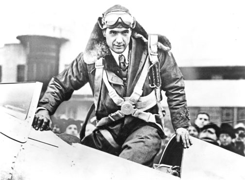 Hughes emerging from an airplane cockpit at Newark Airport