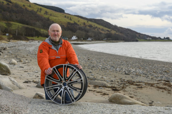 Cameron Park on Pirnmill beach, Arran, with the car wheel which was damaged by a pothole
