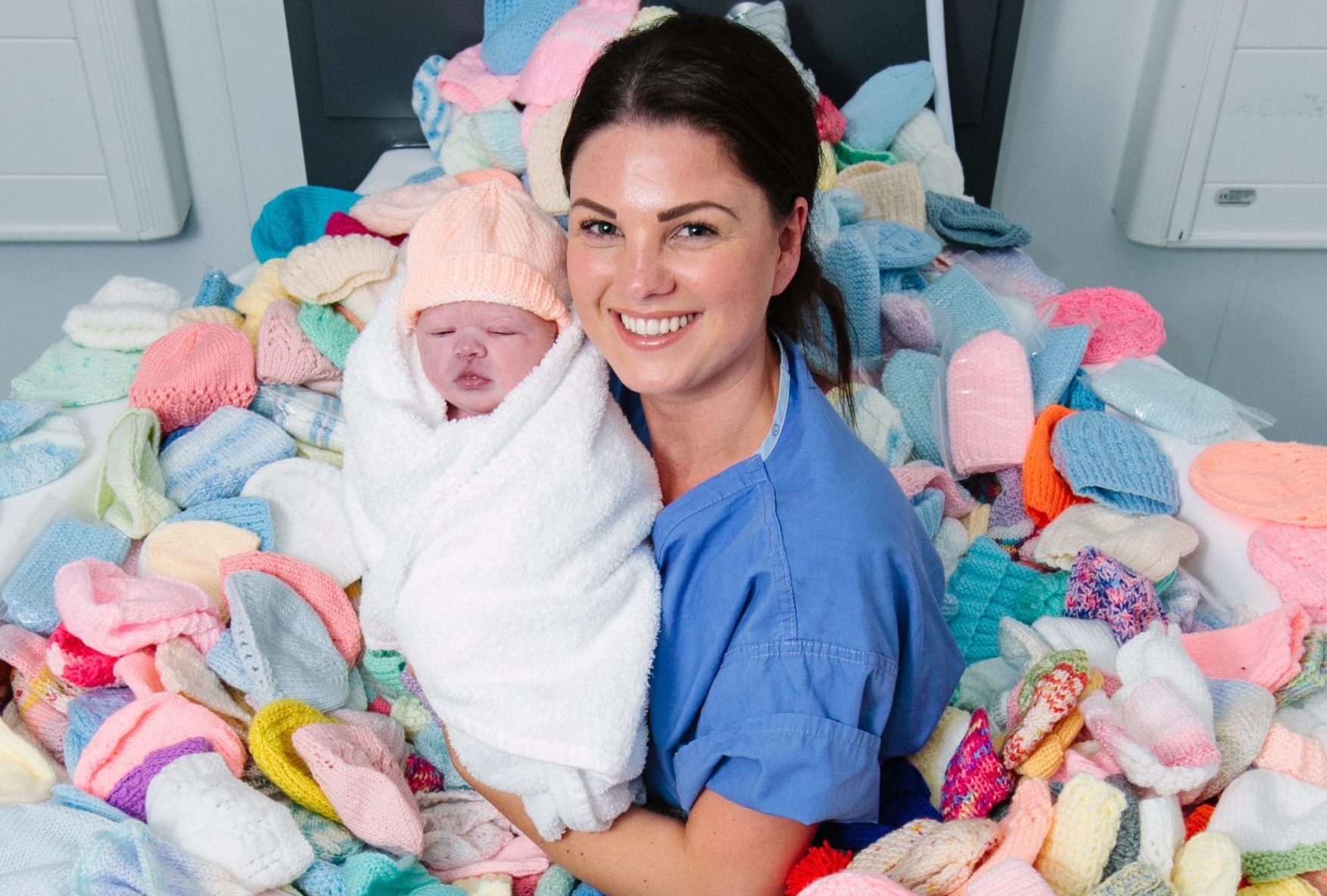 Midwife Lorna McGregor with newborn baby Aria Murray in birthing pool full of baby hats at the Queen Elizabeth University Hospital in Glasgow