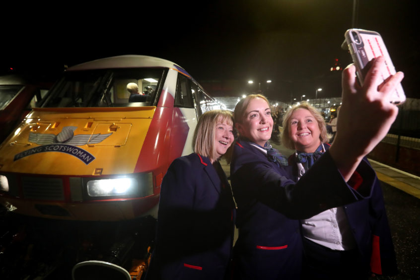 Crew take a selfie beside the cab