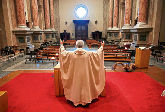 Don Angelo Riva celebrates a mass in an empty church in Carenno, Italy