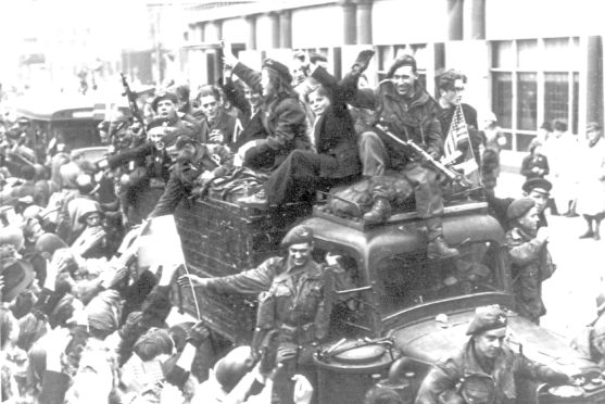 Danes cheer – and some even ride with – British troops as they drive through the streets of Copenhagen in May 1945