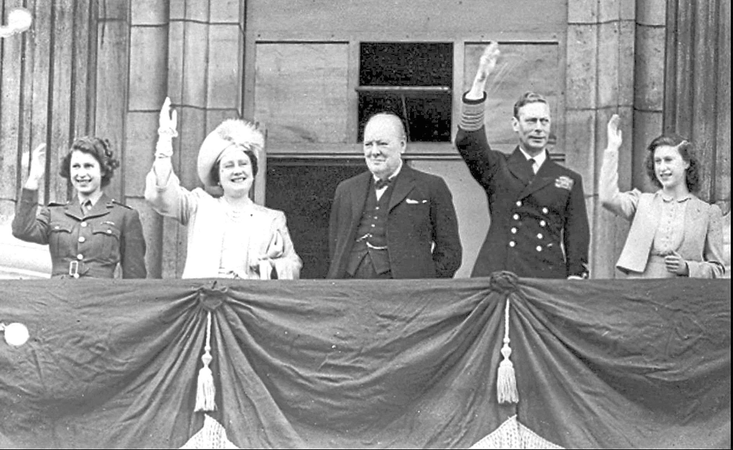 On the balcony at Buckingham Palace overseeing VE Day celebrations are Princess Elizabeth, Queen Elizabeth, Prime Minister Winston Churchill, King George VI and Princess Margaret