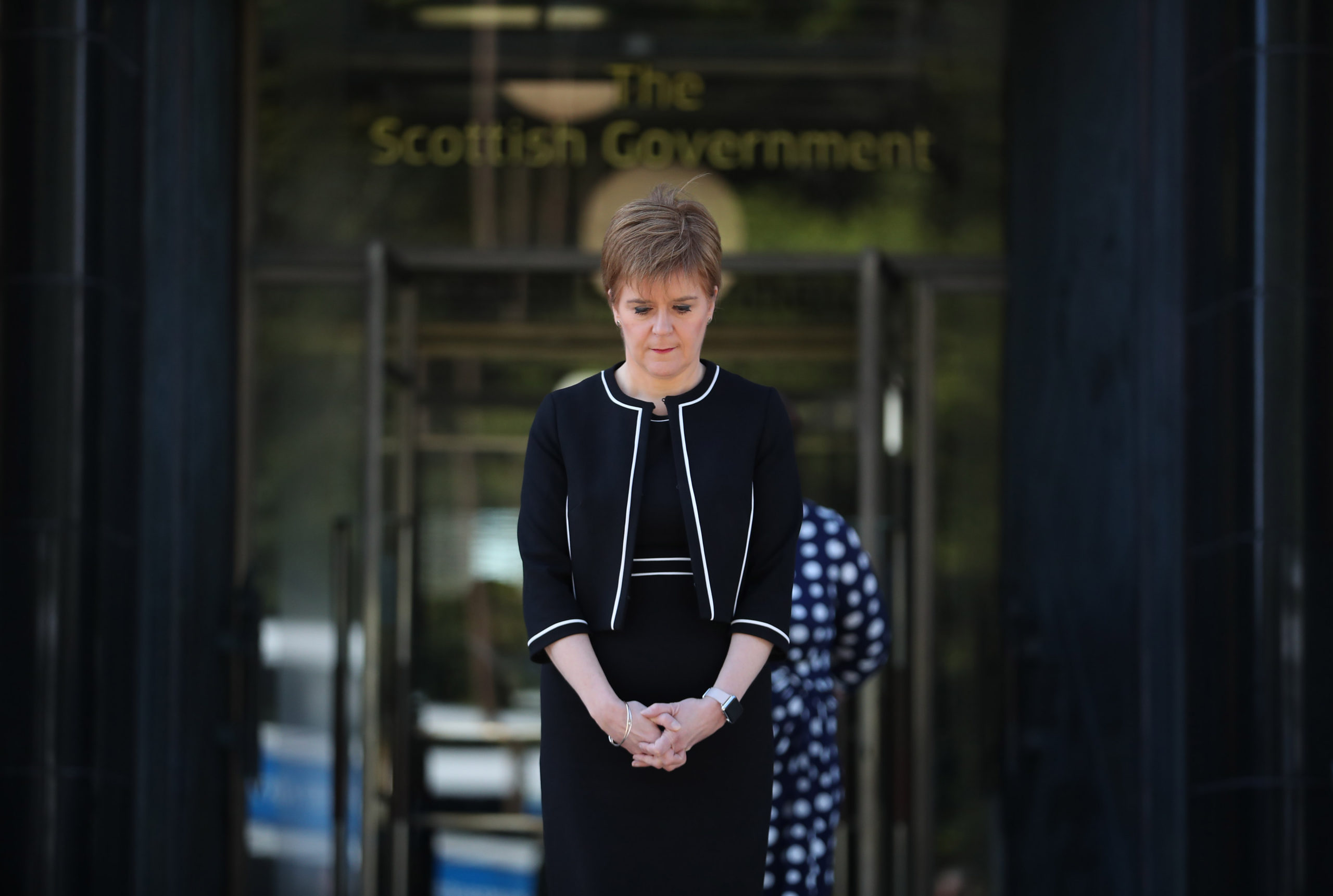First Minister Nicola Sturgeon stands outside St Andrew's House in Edinburgh to observe a minute's silence in tribute to the NHS staff and key workers who have died during the coronavirus outbreak.