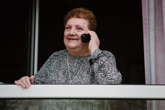 Widow Margaret Foley chats to an Age Scotland volunteer at her home in Glasgow