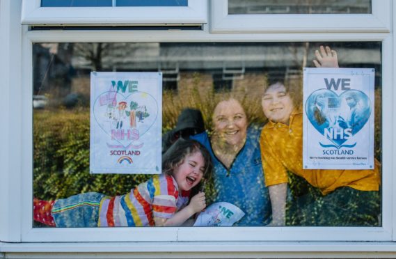 Nurse Pamela Griffin and her children with our poster showing support to the NHS