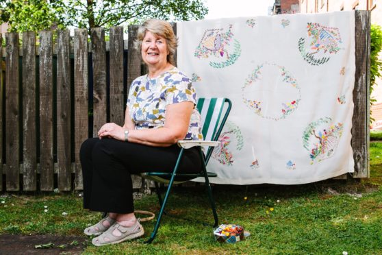 Marion with the finished embroidery at home in Dennistoun, Glasgow