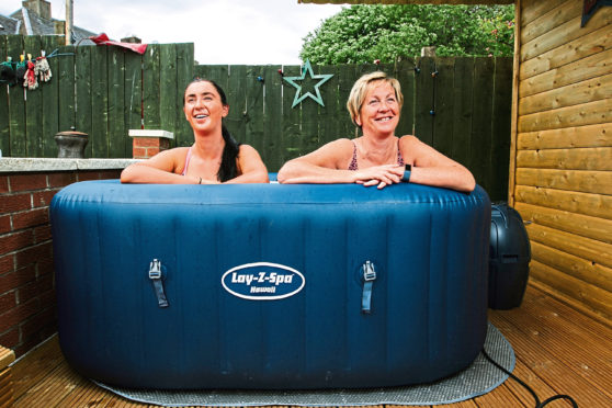 Jacqueline Flanagan, right, is joined by daughter Kathleen in the hot tub at home in Bellshill, Lanarkshire