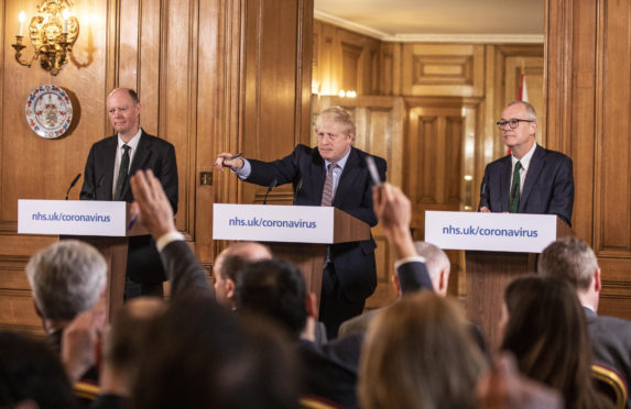 Chief Medical Officer for England Chris Whitty (left) and Chief Scientific Adviser Sir Patrick Vallance stand with Prime Minister Boris Johnson during a media briefing in Downing Street