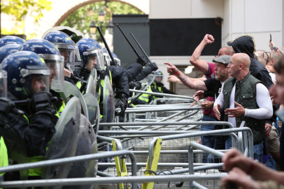 Police are confronted by protesters in Whitehall near Parliament Square, London