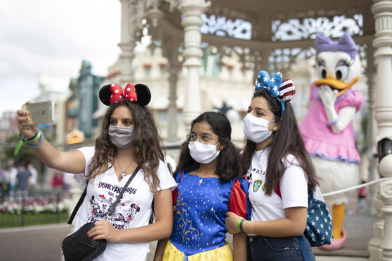 Masked guests on a Selfie Spot to take a picture with Daisy Duck at Disneyland Paris